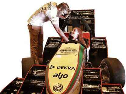 <p> Katharina Hildebrandt sitzt im Rennwagen. Jonas Fromme pr&uuml;ft den Sitz des Gurtes.</p>