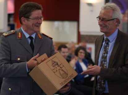 Oberb&uuml;rgermeister Axel Jahnz (rechts) &uuml;bergab ein Pr&auml;sent der Stadt Delmenhorst an Generalmajor Volker Thomas.