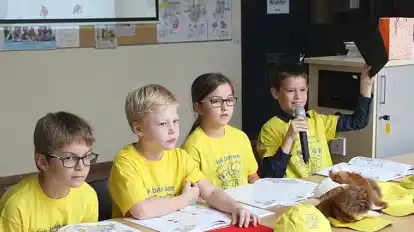 Leon Hinrichs (v.l.), Simon Schade, Joana Limbeck und Leon Blechschmidt lasen aus dem neuen Buch mit dem Seelterfoaks vor. Die Mitsch&uuml;ler durften zudem raten und auf Seeltersk sagen, welche Farben gezeigt wurden, wie hier Schwarz (Swot).