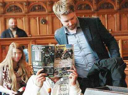 Ali M. bedeckt sein Gesicht mit einer Zeitschrift. Rechts neben ihm sein Verteidiger Torben M&uuml;ller.