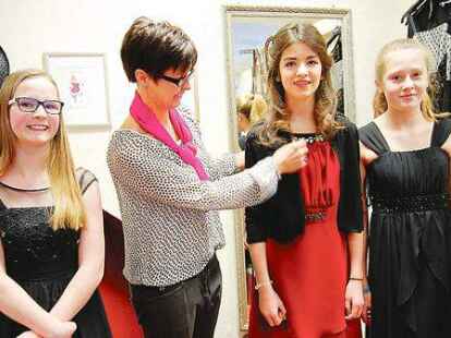<p>Kleideranprobe f&uuml;r die Konfirmation: Julia Marks (von links), Silja Reiser und  Mia Schoof  lassen sich von   Roswitha Leurs bei der Auswahl beraten.</p>