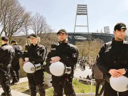 Polizisten stehen vor einem Werder-Spiel auf dem Osterdeich vor dem Weserstadion. Um die Kosten f&uuml;r die Eins&auml;tze bei Hochrisikospielen ist ein Streit entbrannt.