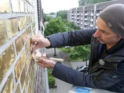 Der K&uuml;nstler Boran Burchhardt hat damit begonnen, die Hauswand eines Geb&auml;udes im sozial schwachen Hamburger Stadtteil Veddel zu vergolden.