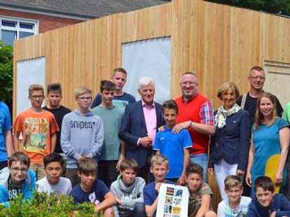 Ein Holzhaus als neue Spielausleihe: Obersch&uuml;ler,  Lehrer, Vertreter der Rotary-Clubs und Handwerker. ing
