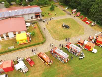 Imposantes Luftbild: Ein Blick von oben auf das Feuerwehrhaus in Scharrel und die Fahrzeuge beim Tag der offenen T&uuml;r.
