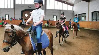 Hopp, Hopp, Hopp: Lina (7) reitet Voran, und die anderen jungen Reiter folgen ihr in Schlangenlinien durch die Reithalle. Anweisungen gibt dabei Leiterin Anna Hinners aus der Mitte.