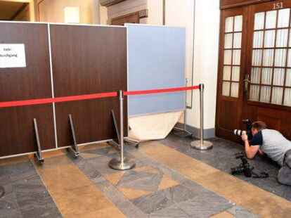 Ein Pressefotograf fotografiert  im Neuen Rathaus in Hannover unter Sichtschutzw&auml;nden.