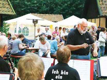 Dirigierte vor zahlreichen Besuchern das Blasorchester: Steffen Akkermann (Mitte, mit Taktstock) und die &bdquo;Harpstedter Prager&ldquo; feierten am Samstagabend  auf dem Koemsgel&auml;nde in Harpstedt das 40-j&auml;hrige Bestehen.