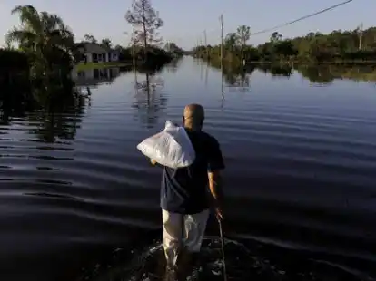 Ein Mann geht in Fort Myers (USA) durch die &uuml;berfluteten Stra&szlig;en nach Hause. Mit Urgewalt ist Hurrikan &bdquo;Irma&ldquo; &uuml;ber Florida hinweggezogen und hat schwere &Uuml;berflutungen und Sturmsch&auml;den mit sich gebracht.
