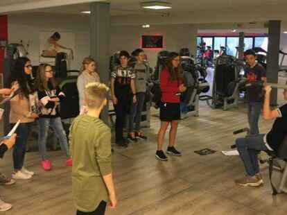 Die Klasse 8.5 der IGS Friesland Nord war am 6. Dezember bei Viva Fitness in Schortens und hat sich von den Fitnesstrainern Janosch Brunken und Ina Heyen die verschiedenen Ger&auml;te erkl&auml;ren lassen. Dabei durften die 26 Sch&uuml;ler viele &Uuml;bungen selbst ausprobieren.