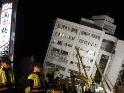 Zwei Polizisten bewachen nach dem Erdbeben ein eingestürztes Gebäude. Das  Erdbeben erreichte eine Stärke von 6,4. und hat sich am 6. Februar um 16.50  Uhr (Ortszeit/MEZ) in Taiwan ereignet, wie die US-Erdbebenwarte USGS meldete.
