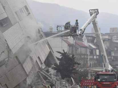 Die Feuerwehr bekämpft die Staubwolken in dem durch ein Erdbeben schwer beschädigten Yuntsui Building.