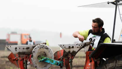 Teilnehmer Johann Singer reinigt das Scheibensech an seinem Trecker.