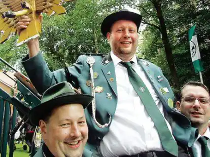 Marco Deddens (Mitte)  ist der neue Sch&uuml;tzenk&ouml;nig in Varrelbusch. Die Sch&uuml;tzen trugen ihn auf H&auml;nden.