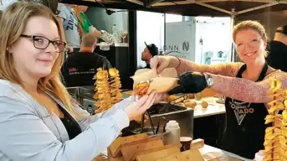 &bdquo;Kartoffel-Tornados&ldquo;, frisch frittierte  Kartoffelscheiben am Spie&szlig;, lie&szlig; sich Kyra Gertje (links) aus Augustfehn von Lena Glauser (rechts) servieren.