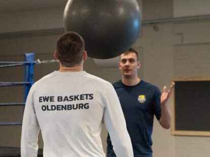 Rasid Mahalbasic und Nathan Boothe spielen Ball.