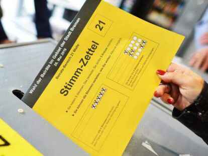 Stimmabgabe in Bremen: Eine B&uuml;rgerin wirft in einem Wahlb&uuml;ro ihren Wahlzettel in eine Urne.