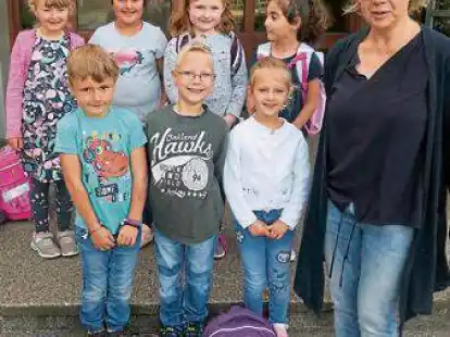 Sieben Jungen und M&auml;dchen pr&auml;sentierten sich beim Einschulungsfoto  in Blexen. Ihre Klassenlehrerin ist Stephanie Stoll.