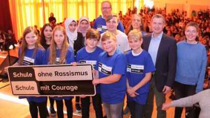 <p>Das wegweisende Schild wird pr&auml;sentiert von Sch&uuml;lern, Lehrer Stefan Brandt, Sozialp&auml;dagogin Tanja Reiher, B&uuml;rgermeister und Pate der Aktion, Christian Pundt, Marie Wilke, Constanze Schnepf (beide Ibis) und Rektorin Silke M&uuml;ller (von links).</p>