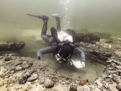 Ein Unterwasserarch&auml;ologe untersucht die eiszeitliche Fundstelle in sechs Meter Meerestiefe an der K&uuml;ste der Kieler Bucht. &ndash; Foto rechts unten:  Ein steinzeitlicher Flintbohrer.