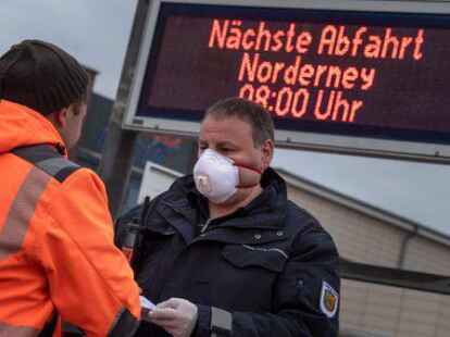Ein Mitarbeiter des Ordnungsamts kontrolliert in Norddeich vor der F&auml;hre nach Norderney die Ausweise.