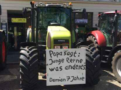 Vor ihren Treckern haben die Landwirte Schilder angebracht.