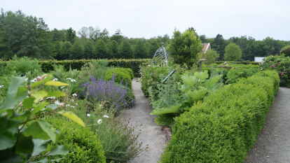 Im typischen Kreuzgang mit Buchsbaumhecken angelegt.
