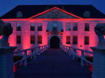 Das Wasserschloss Dornum strahlt rot.