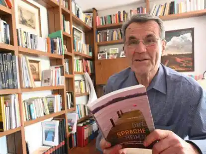 In seinem Wohnzimmer: Autor Erhard Br&uuml;chert mit seinem neuen Buch &bdquo;Ort &ndash; Sprache &ndash; Heimat&ldquo;