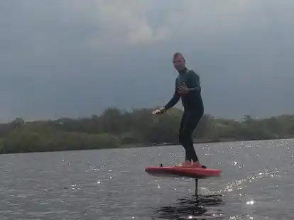 Wie fliegen: Alex Ronniger stehend auf einem Board, welches durch den Hydrofoil-Effekt aus dem Wasser gehoben wurde. In diesem Fall nicht mit Hilfe eines „Wings“, sondern auf einem „E-Foil“.