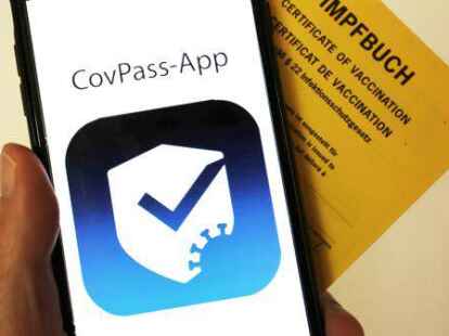 ILLUSTRATION - Das Logo der CovPass-App ist neben einem Impfbuch auf einem Smartphone zu sehen. Der digitale Corona-Impfpass in Deutschland soll an diesem Donnerstag an den Start gehen. (zu dpa: 