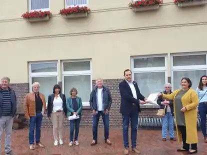 Termin vor dem Aper Rathaus: Natalie Geerlings (2.v.r.) &uuml;bergab zusammen mit anderen  Anliegern der Stettiner Stra&szlig;e und der Stra&szlig;e Am Riehen in Augustfehn Unterschriftenlisten an B&uuml;rgermeister Matthias Huber (4.v.r.).