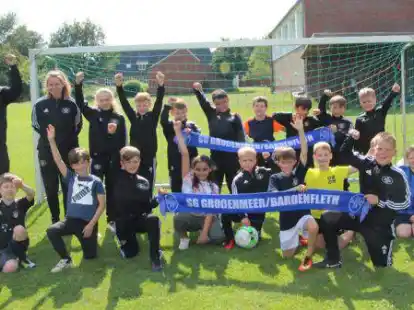 Freuen sich &uuml;ber die neuen Trainingsanz&uuml;ge und den Sieg &uuml;ber die Eltern: Die F-Jugendlichen der Spielgemeinschaft Gro&szlig;enmeer/Bardenfleth mit ihren Trainern Mathias M&uuml;ller und Sofie Siemer (stehend links) sowie Sponsor Hergen Neemann (stehend rechts).