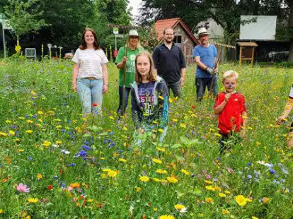 Freuen sich &uuml;ber das gelungene Projekt: Die Kinder Marie, Nico und Janne (vorne) mit Fentke Stolle, Heike K&ouml;ster, Mathis Einemann und Manfred K&ouml;ster (hinten, von links), inmitten der Bl&uuml;hwiese.