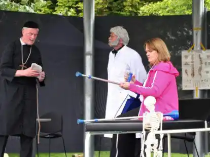 Zwiegespr&auml;ch im Krankenzimmer: (v.li.) Pfarrer Kneipp (gespielt von Jens Oeltjendiers-Odion) und Dr. Sch&uuml;&szlig;ler (Detlef Lohse) sprechen &uuml;ber die richtige Behandlung von Kurgast Elfriede von Tecklenburg (Andrea Alberts). Da gehen die Meinungen schon mal auseinander.