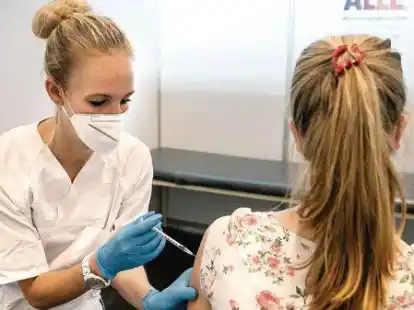 Eine junge Frau wird im Impfzentrum geimpft.