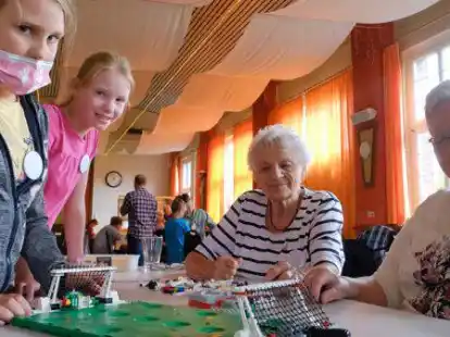 Auch ein Fu&szlig;ballplatz geh&ouml;rt in die Lego-Stadt: Anike Kampen (9), Leefke Sommer (9), Dore Riekena (87) und Gisela Hollander (82, von links) haben ihn gebaut.