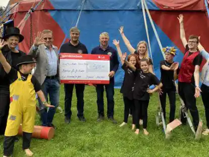 Harald Hillmer und Peter Jelkmann von den Lions Nordenham/Elsfleth (Mitte) &uuml;berreichten den Unterst&uuml;tzer-Scheck vor dem Zirkuszelt. Jetzt werden dringend noch Helfer f&uuml;r den Abbau des Zeltes gesucht.