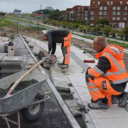 Wilfried Weyerts und Alwin Hanssen (r.) arbeiten mit Hochdruck daran, die letzten Steine am Deich zu verlegen.