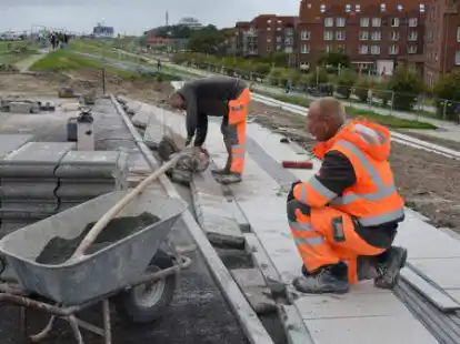 Wilfried Weyerts und Alwin Hanssen (r.) arbeiten mit Hochdruck daran, die letzten Steine am Deich zu verlegen.