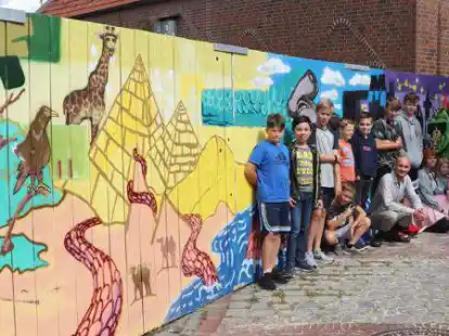 Stolze K&uuml;nstlerinnen und K&uuml;nstler: Die jungen Menschen haben 25 Meter Bauzaun in Westerstede bemalt. Dabei bekamen sie Unterst&uuml;tzung von Leon Bohlsen und Tim Lichte.