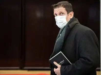 Olaf Latzel kommt mit einer Bibel in der Hand in den Gerichtssaal. Zur Kl&auml;rung seines Falls wird nun auch ein theologisches Gutachten erstellt.