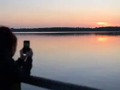Bad Zwischenahn ist immer eine Reise wert - hier fotografiert eine Frau mit ihrem Handy den Sonnenuntergang am Zwischenahner Meer. Im Corona-Jahr 2020 tat sich der Tourismus in Niedersachsen dennoch schwer.