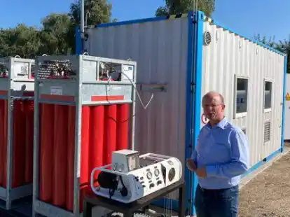 Der Container mit Speicherb&uuml;ndel (links) : Hilmer Heineke von New Power Pack steht vor der Anlage in Goldenstedt, in der  Wasserstoff aus &Ouml;kostrom produziert wird.