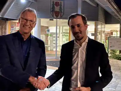 Shakehands vor der Stichwahl in 14 Tagen: Guido Heinisch und Bastian Ernst (von links) am sp&auml;ten Sonntagabend vorm Hatter Rathaus