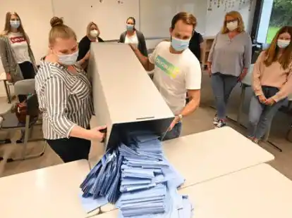 Um 18 Uhr ging es los: Stella Runde (vorne, links) und Moritz Berger sch&uuml;tten einen der Wahlurnen mit den Briefwahlstimmen aus.