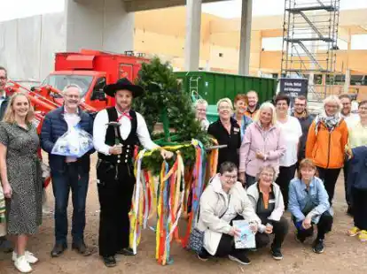 Zimmermann Christoph von Minden befestigte den Richtkranz auf dem Dach, sehr zur Freude von Petra Kosten sowie Gesa und Bernd Oetken (vorne, von links).
