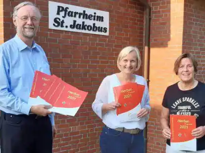 Pfarrer Ludger Fischer, Birgit Walker und Brigitte Bott pr&auml;sentieren vor dem Pfarrheim Ramsloh das neue Herbstprogramm des Bildungswerks.