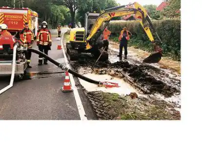 Wasserrohrbruch an der Westersteder Stra&szlig;e: Die Feuerwehr pumpte das Wasser &uuml;ber die Fahrbahn in einen Graben, w&auml;hrend Fachleute nach der Schadstelle suchten.