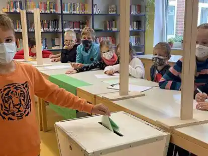 Stimmzettel in die Wahlurne: Die kleinen Wahlhelfer &uuml;berwachten das korrekte Einwerfen.
